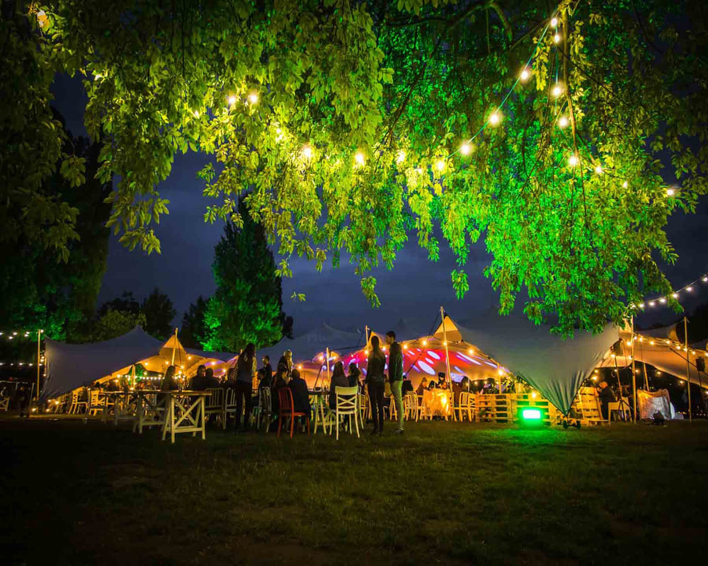 Location d'une tente nomade avec guirlande lumineuse dans les arbres pour une soirée extérieure. Installation par DUO'Z EVENTS.
